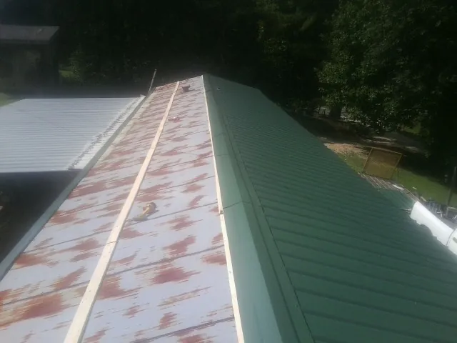 Old rusted panels beside newly installed green metal roofing — Wind Damage Roof Repair by Roofing Brothers in Palos Park