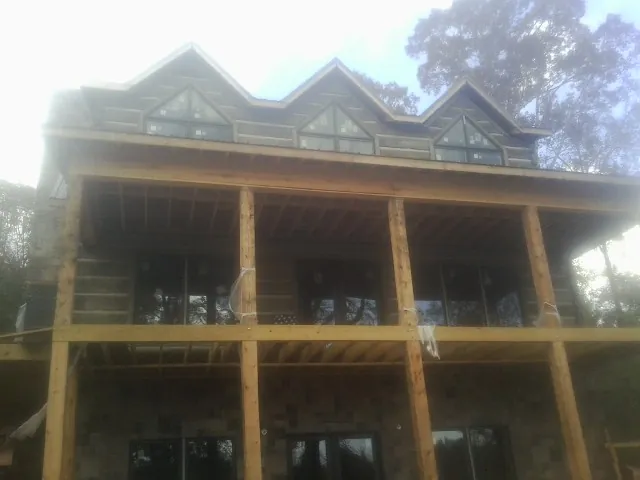 Dormers and porch framing on a large log home under construction — Roof Coating work by our crew in Palos Park