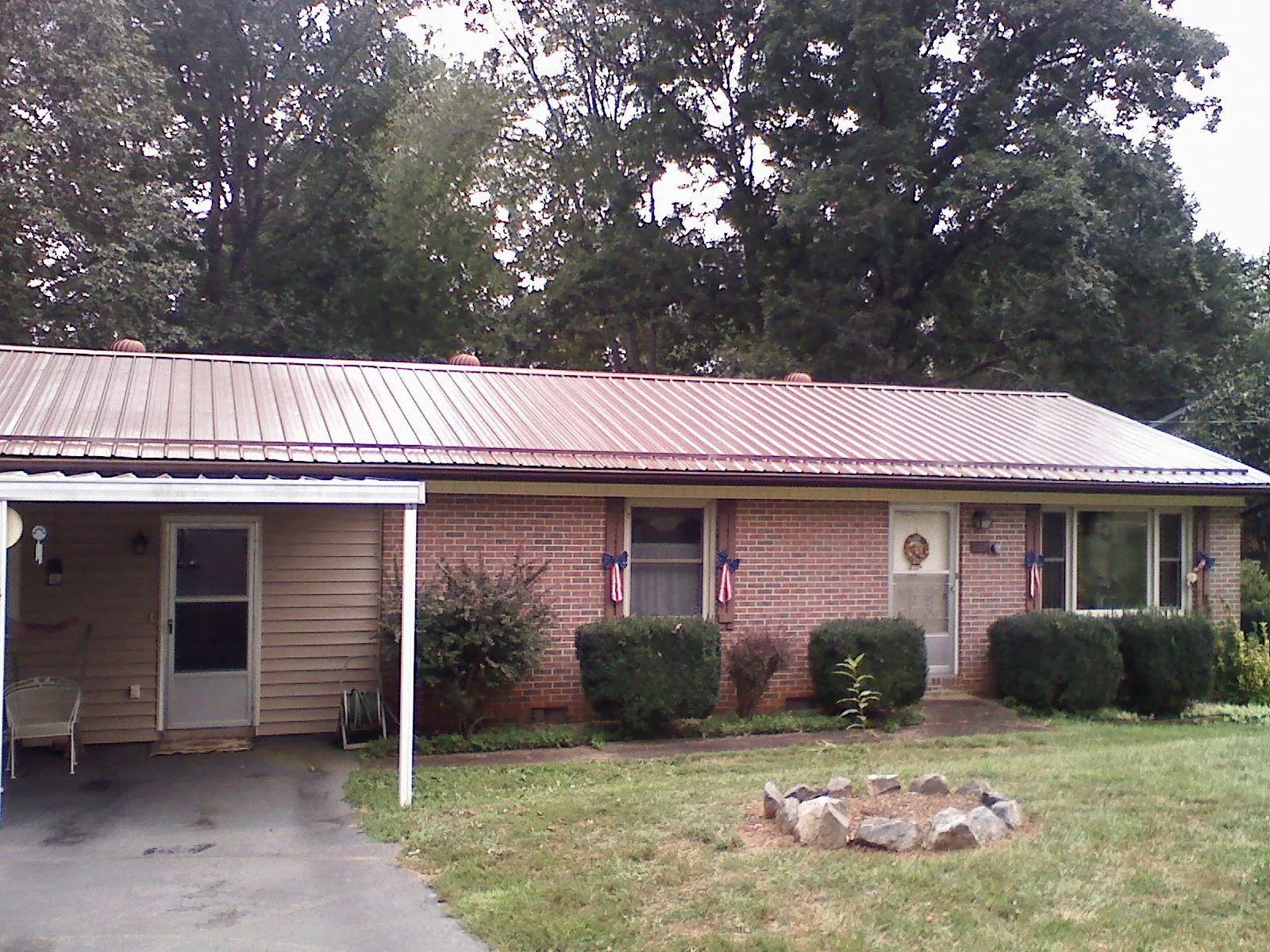 Bronze metal roof and carport on a brick ranch home — Roof Repair work by our crew in Palos Park